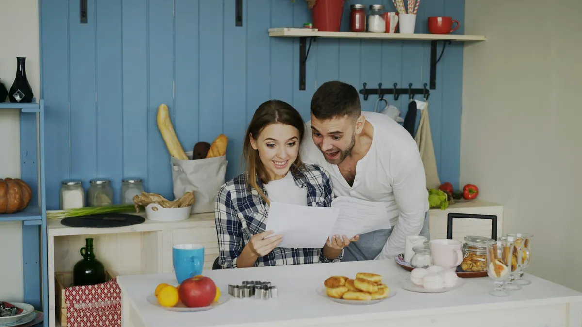 Couple examinant des documents à la table de la cuisine