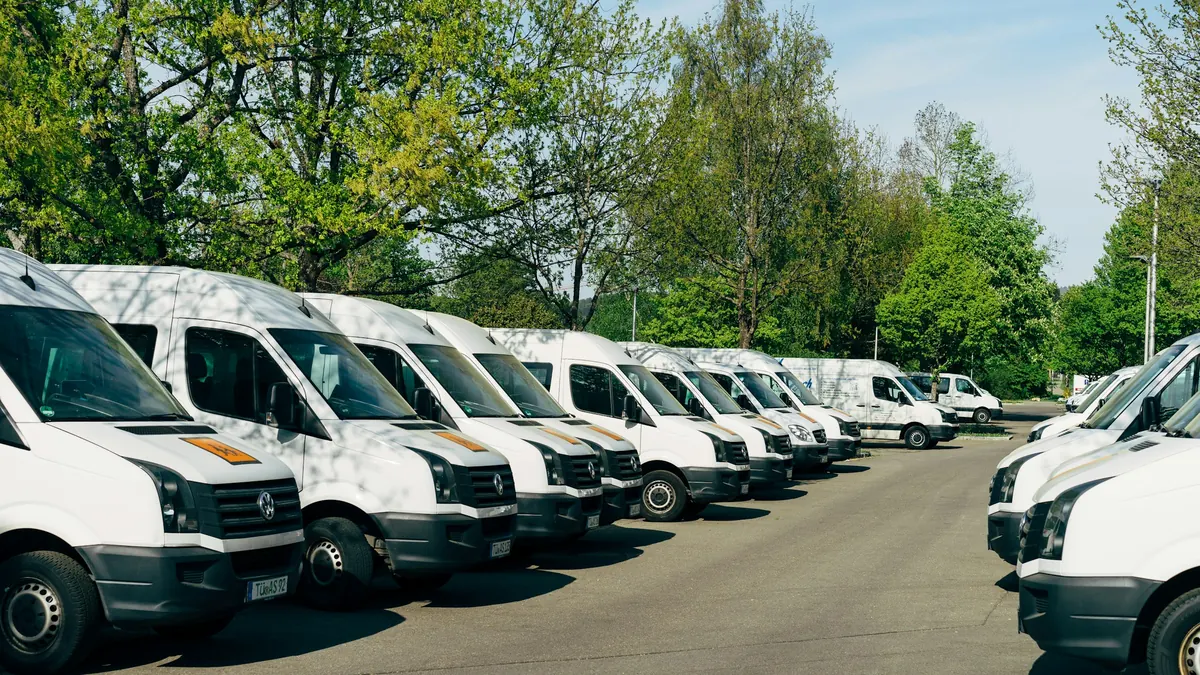 Rangée de fourgons utilitaires blancs garés sur un parking